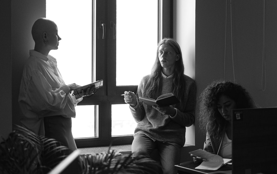 A group of people sitting in front of a window.