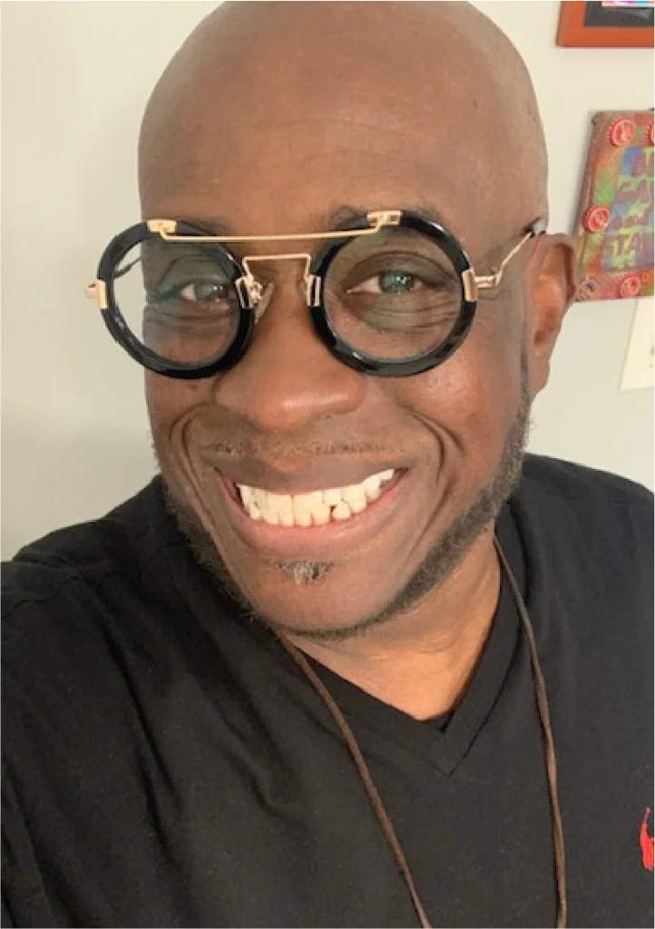 A man with glasses smiling for the camera.